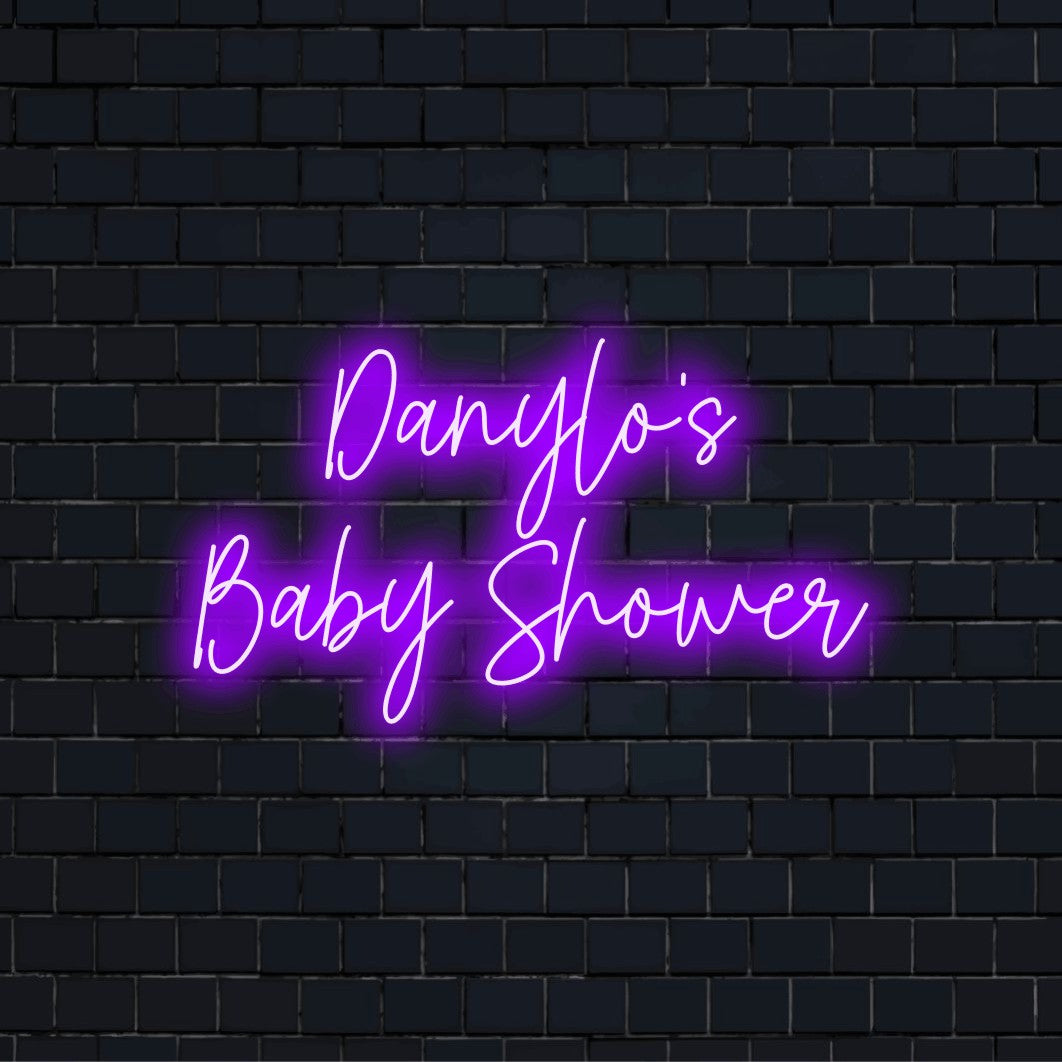 Danylo_s Baby Shower Custom Name Neon Sign, glowing neon text against black brick wall