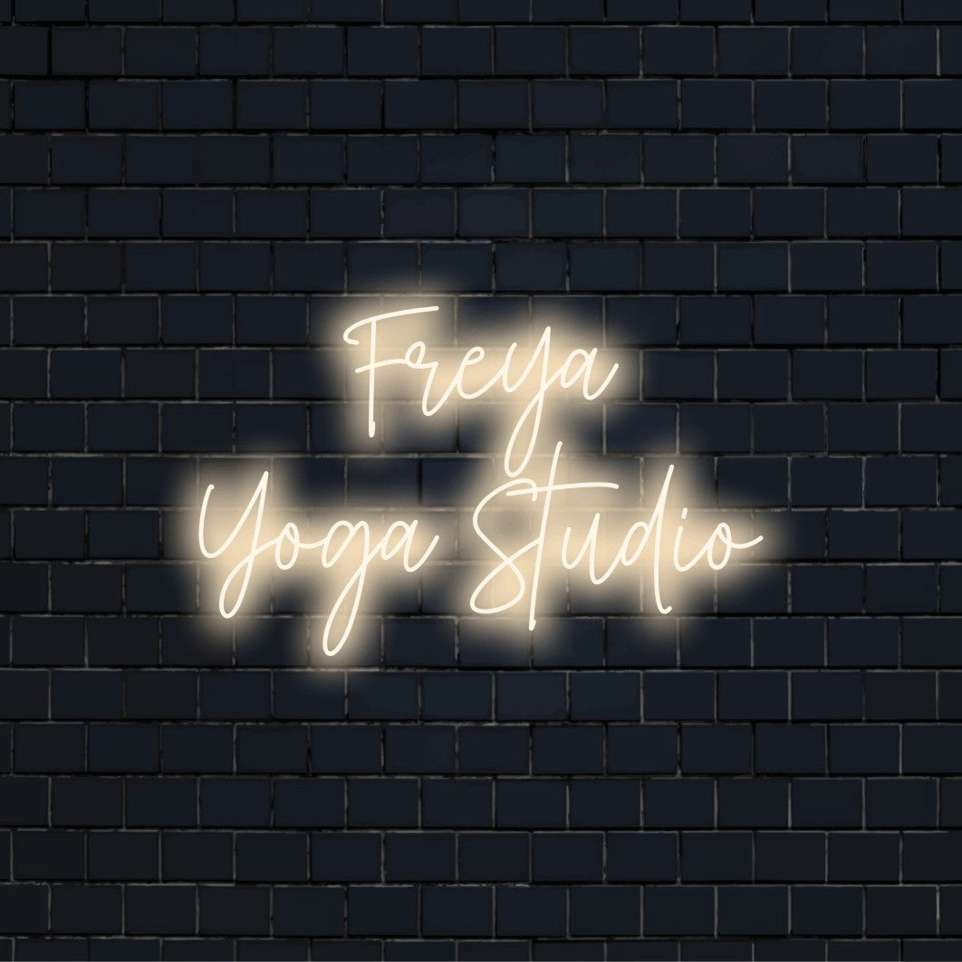 Freya Yoga Studio Custom Name Neon Sign, glowing wall decor on dark brick wall
