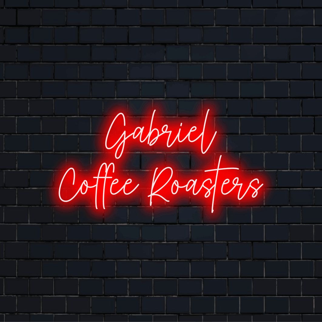 Gabriel Coffee Roasters Personalized Neon Light with bright neon glow on dark brick wall