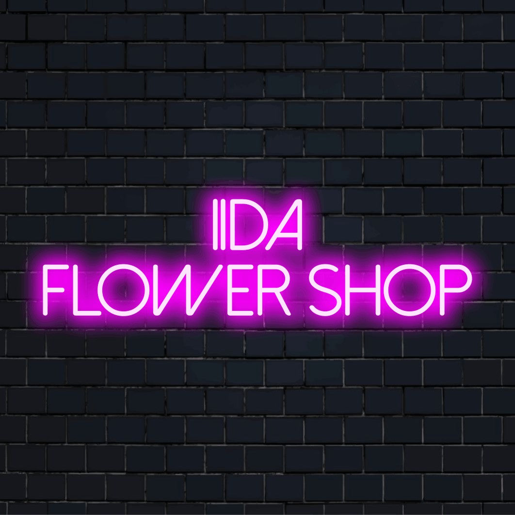Iida Flower Shop Custom Name Neon Sign, bright LED glow on dark brick wall