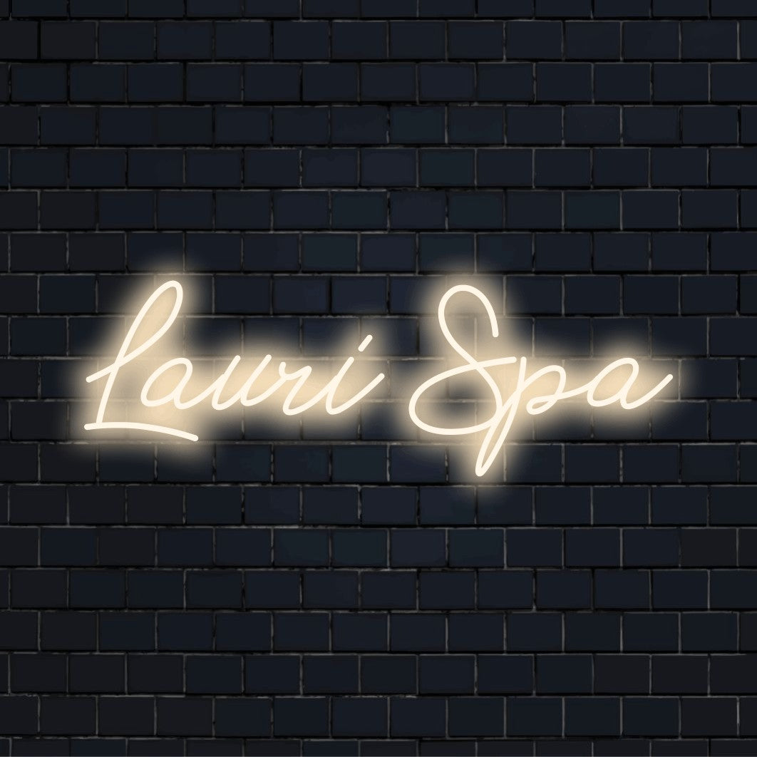 Lauri Spa Custom Name Neon Sign, glowing lettering against black brick wall