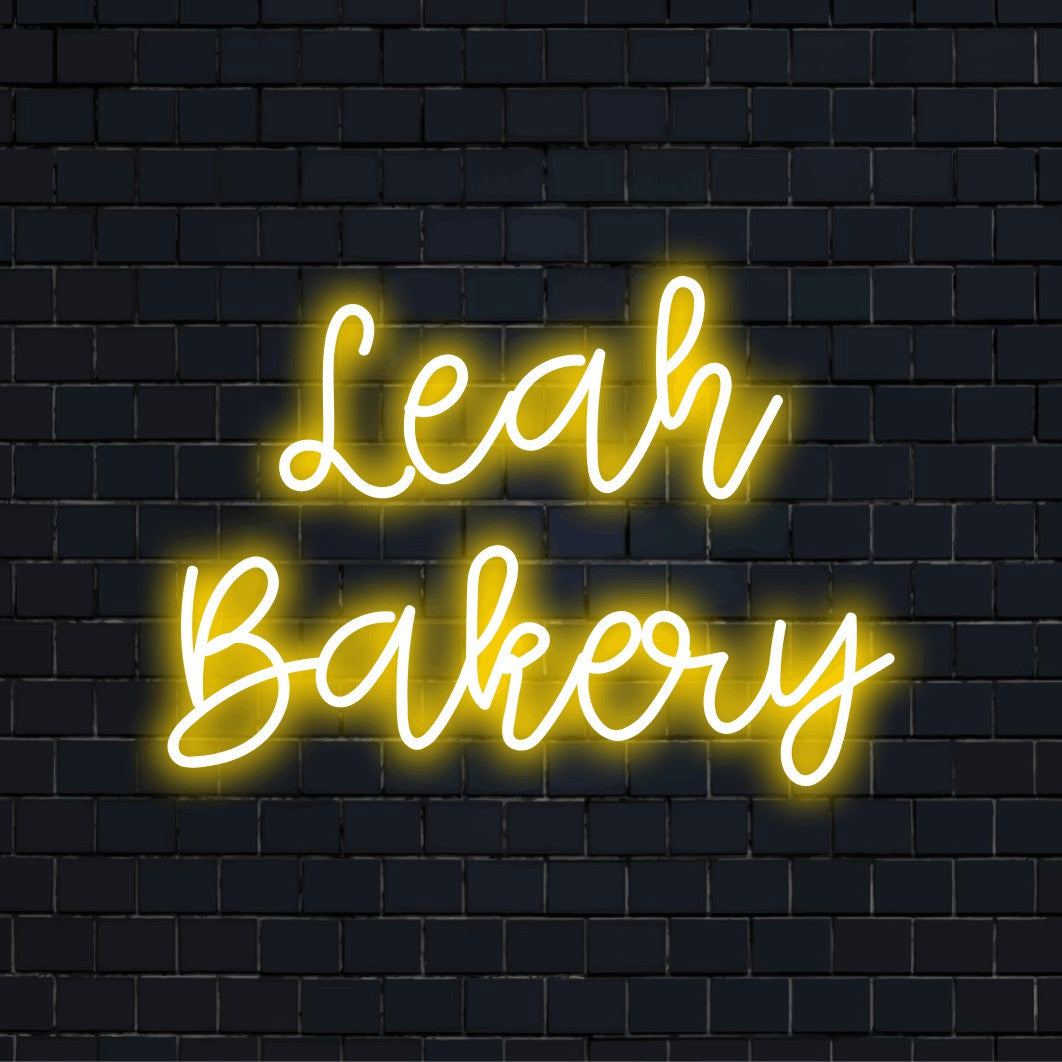 Leah Bakery Personalized LED Neon Sign, glowing wall decor against black brick wall