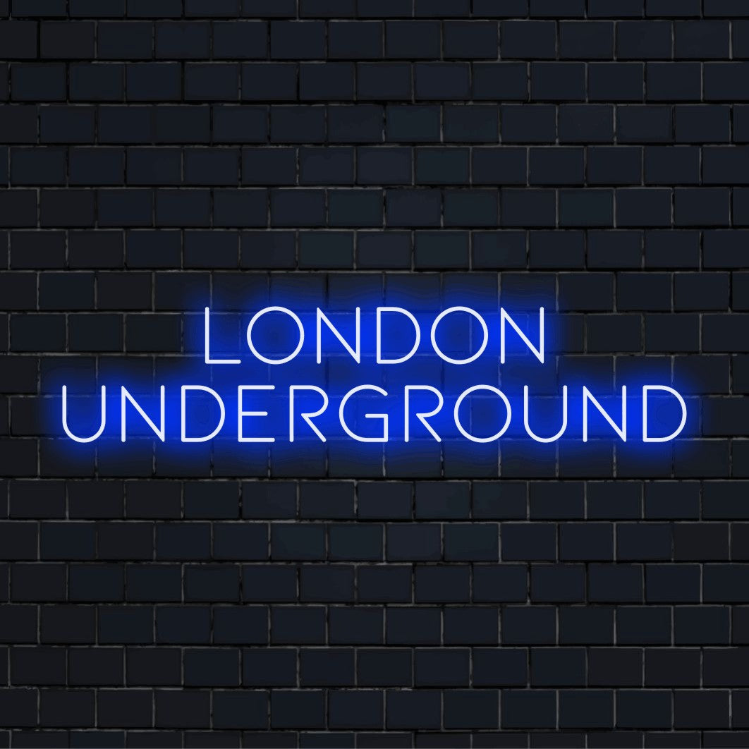 London Underground Neon Sign, bright neon lettering on dark brick wall