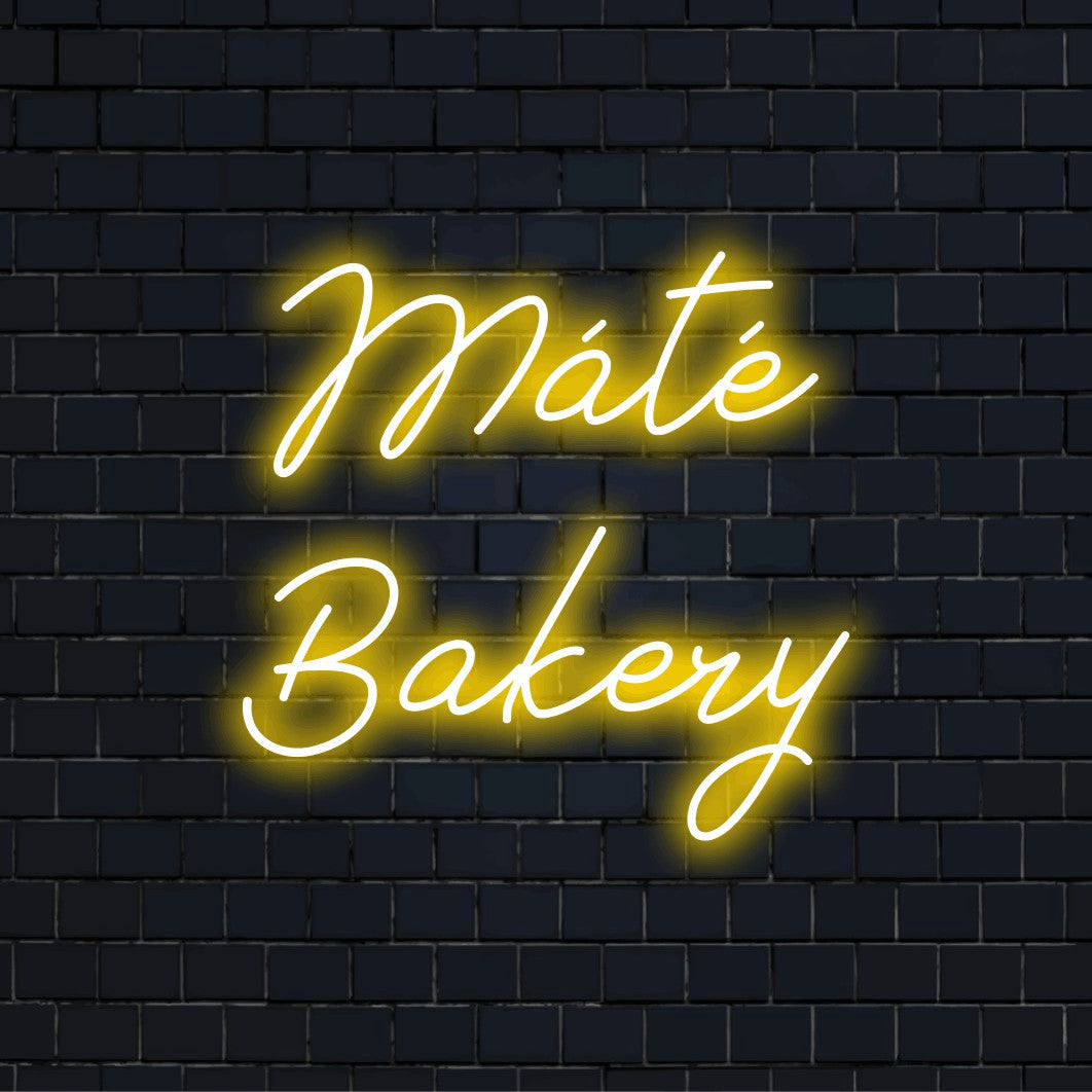 Mate Bakery Personalized Neon Light with glowing neon text against brick backdrop
