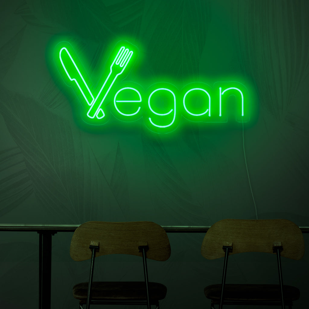 En neonskylt med texten "Vegan", som representerar konceptet med växtbaserad mat med sitt livfulla gröna ljus.
