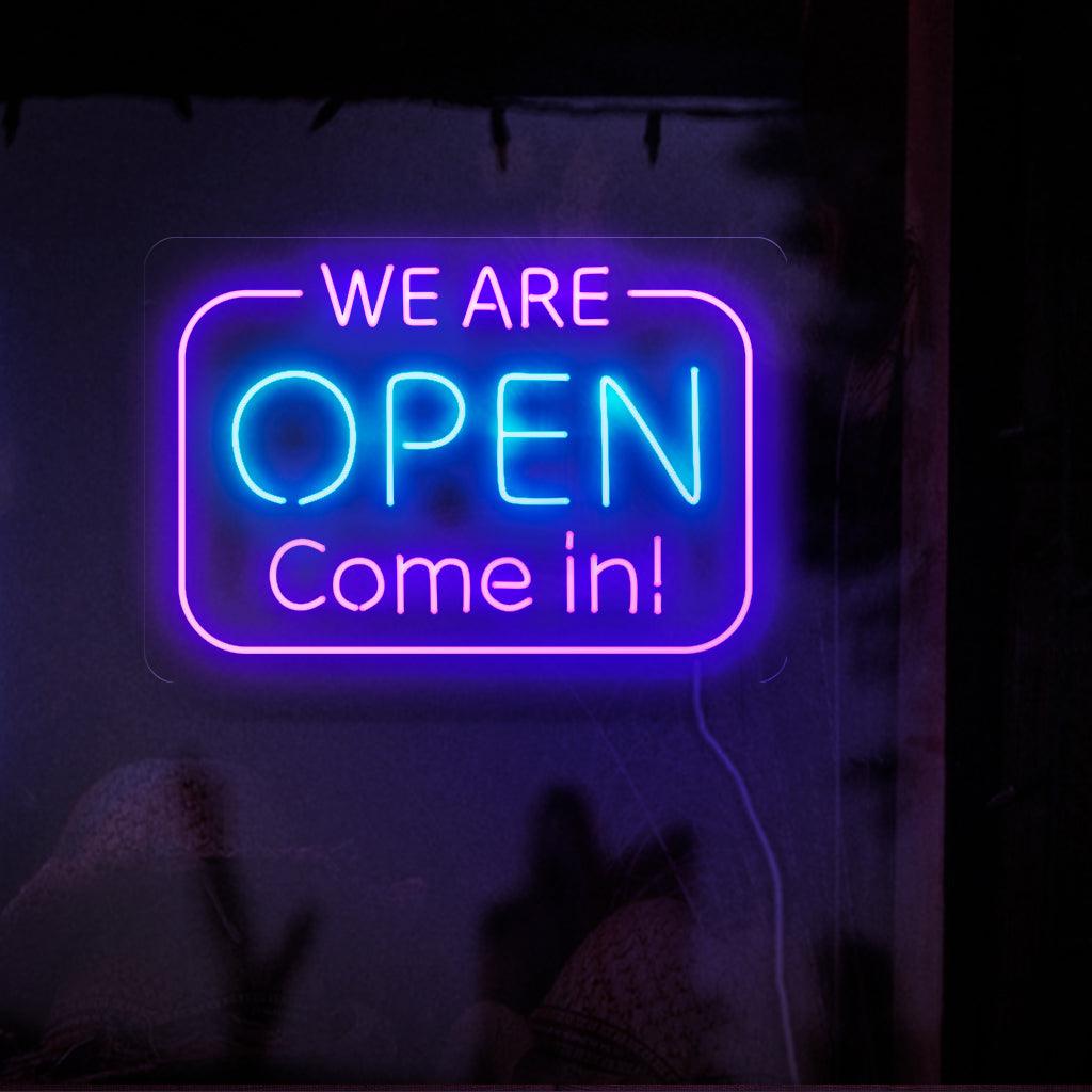 En fängslande neonskylt med djärva, glödande bokstäver som stavar "We Are Open". Komma in.'
