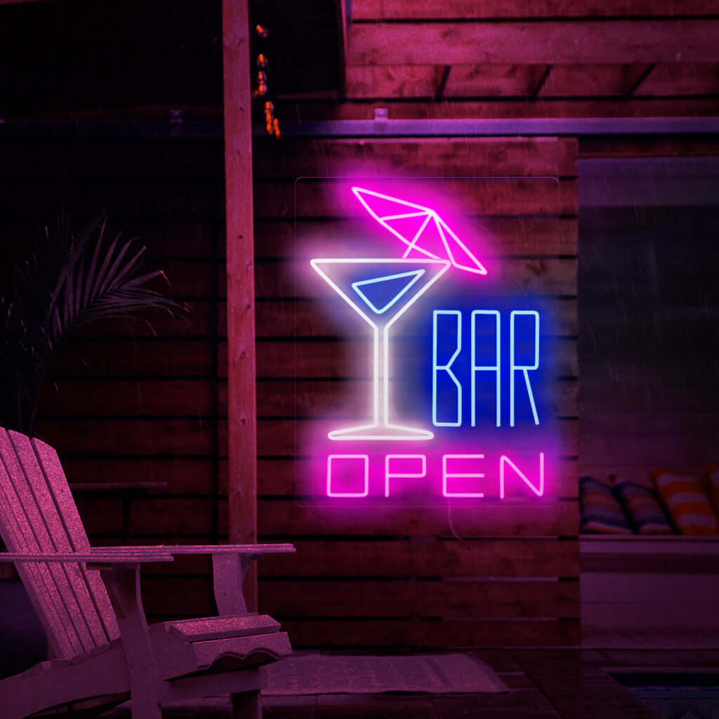 Bilden visar en neonskylt med en cocktail med ett paraply till vänster och texten "öppen bar" till höger. Denna neonskylt är idealisk för barer, både inomhus och utomhus.