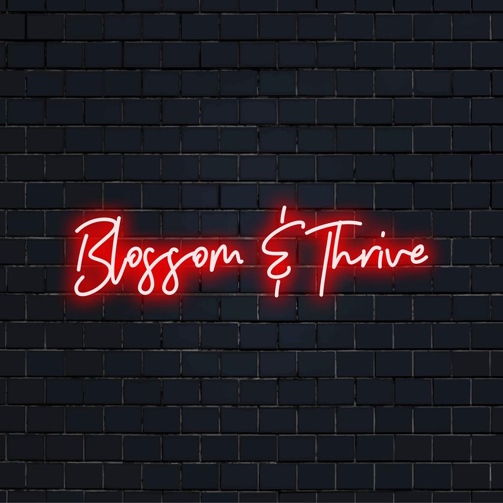 LED neonskylt med 'Blossom And Thrive' i livfulla färger, perfekt för inspirerande neonkonst och dekor.