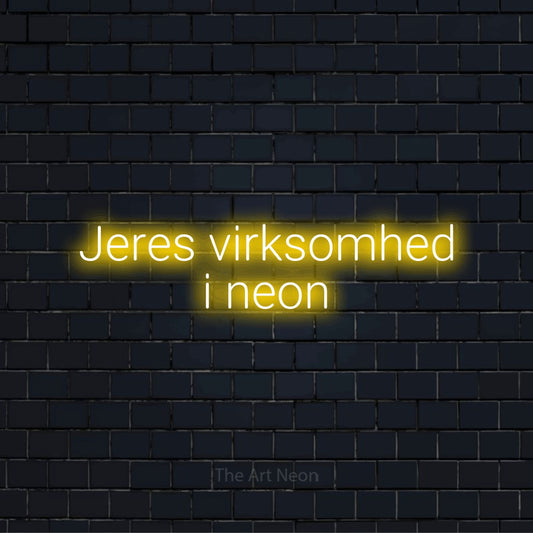 Personligt neonskilt med teksten “Jeres virksomhed i neon” på en sort murstensvæg