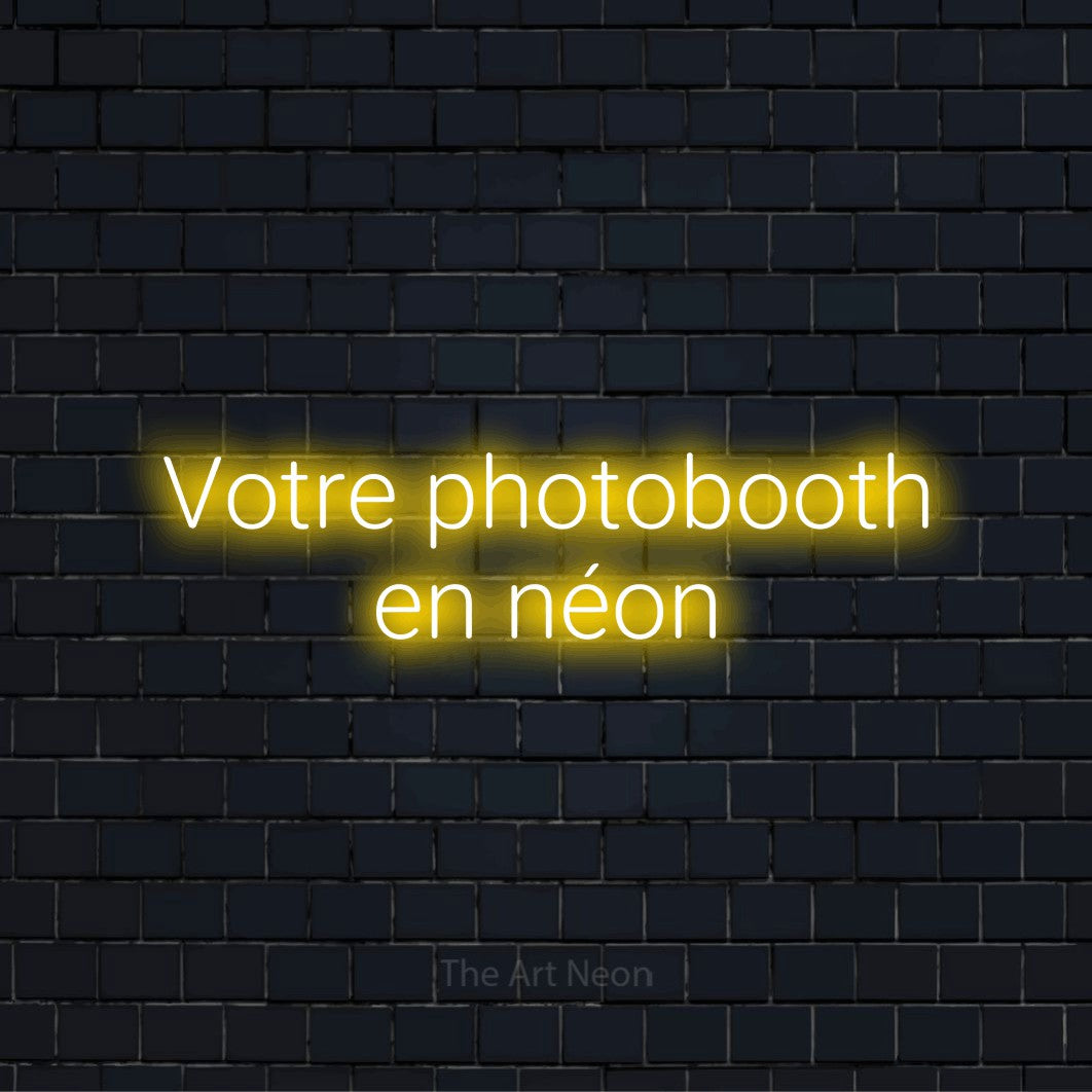 Enseigne néon personnalisée « Votre photobooth en néon » sur un mur en briques noires