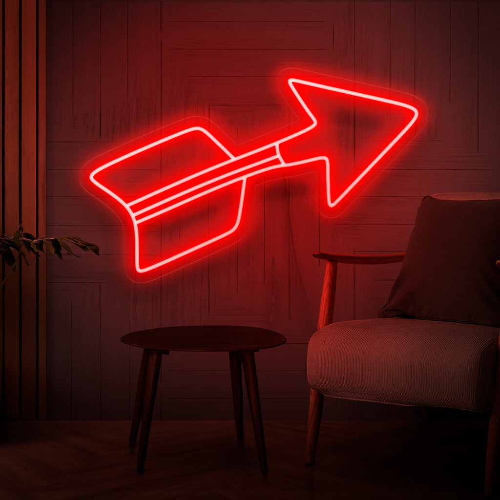 En upplyst neonskylt med en livlig röd pil, som symboliserar riktning och pekar mot ett elegant och dekorativt element, vilket lägger till en fängslande fokuspunkt till alla utrymmen.