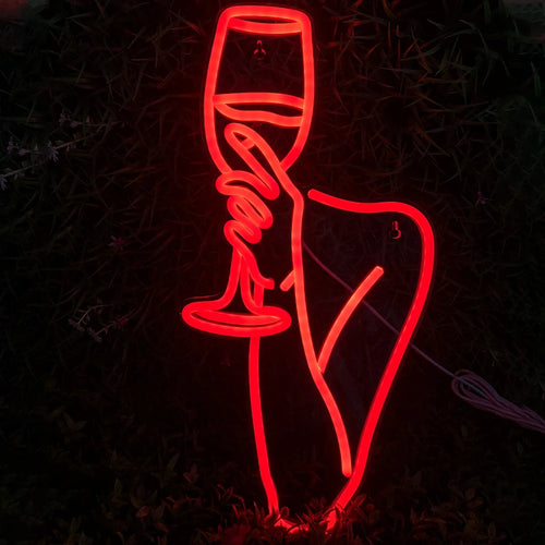 Bilden visar en levande LED-neonskylt som visar en kontur av en kvinna som håller i ett vinglas.