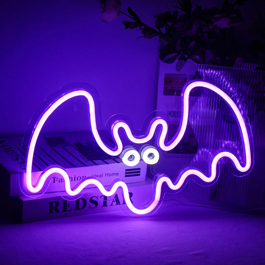 The image depicts a vibrant handmade LED neon sign shaped like a bat.