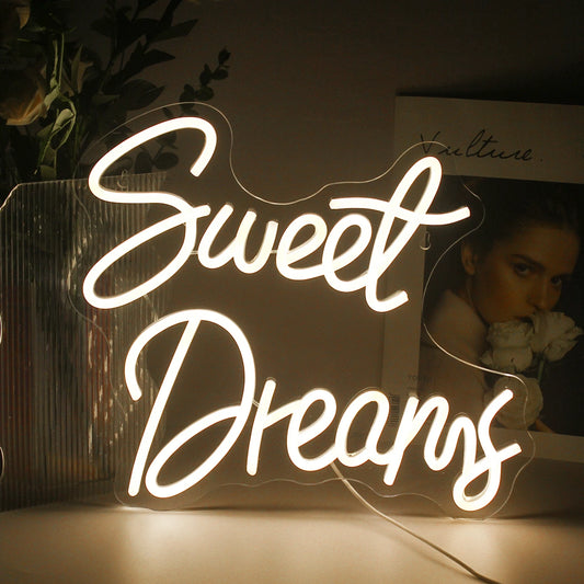 The image showcases a stylish and vibrant LED neon sign displaying the words "Sweet Dreams" in a flowing, cursive font.