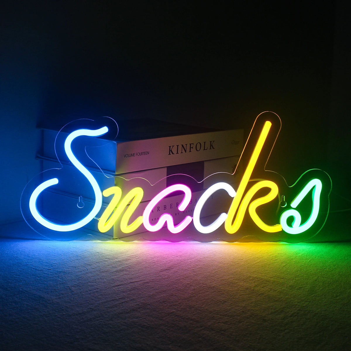 Bilden visar en levande, handgjord LED-neonskylt med texten "Colorful Snacks.