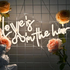 Bilden har en levande, handgjord LED-neonskylt som stavar frasen "Love is in the Hair.