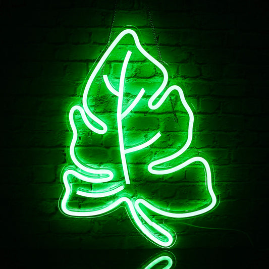 The image features a vibrant LED neon sign shaped like a green leaf.