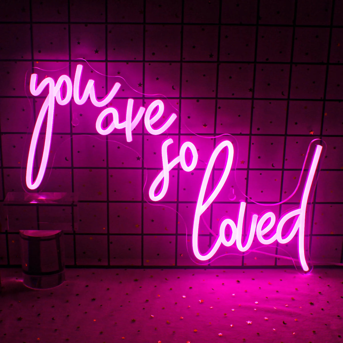 Bilden har en levande LED-neonskylt som visar orden "Du är så älskad" med eleganta, kursiva bokstäver.