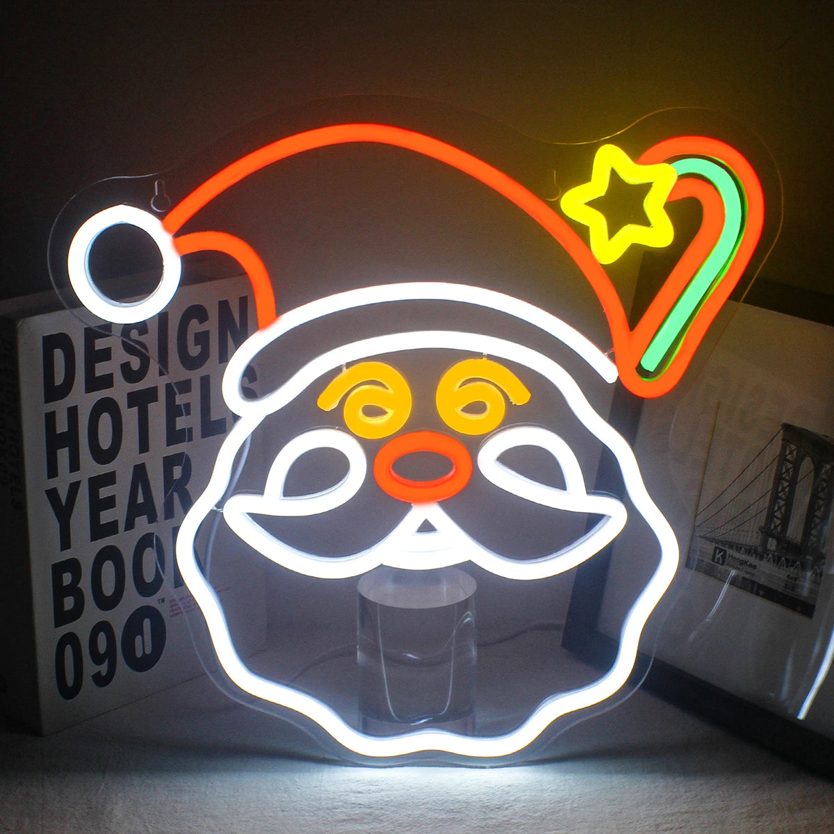 En levande LED-neonskylt med jultema med en rad festliga symboler upplysta i ljusa färger.