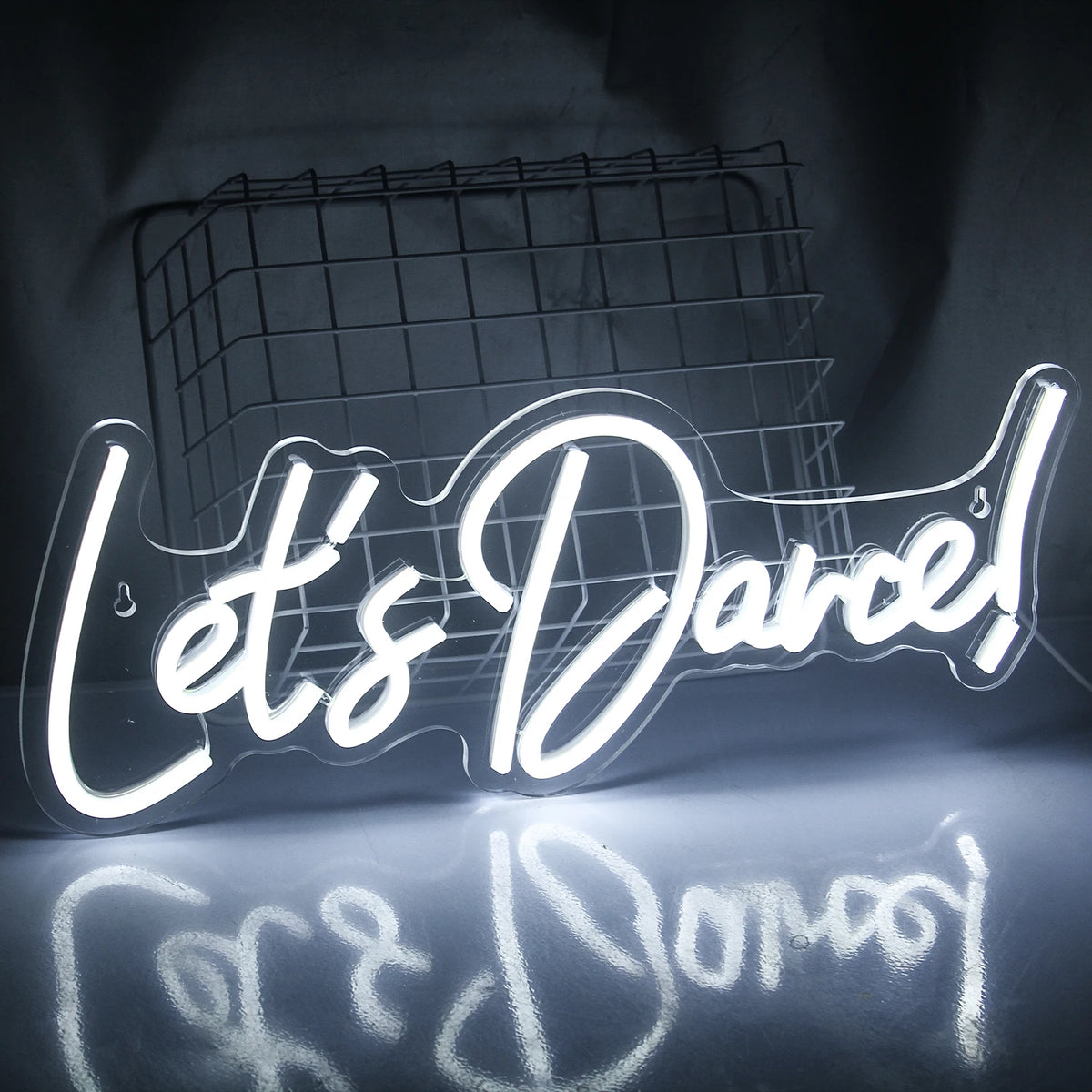 En starkt upplyst "Let's Dance" LED-neonskylt i livfulla rosa och blå färger.