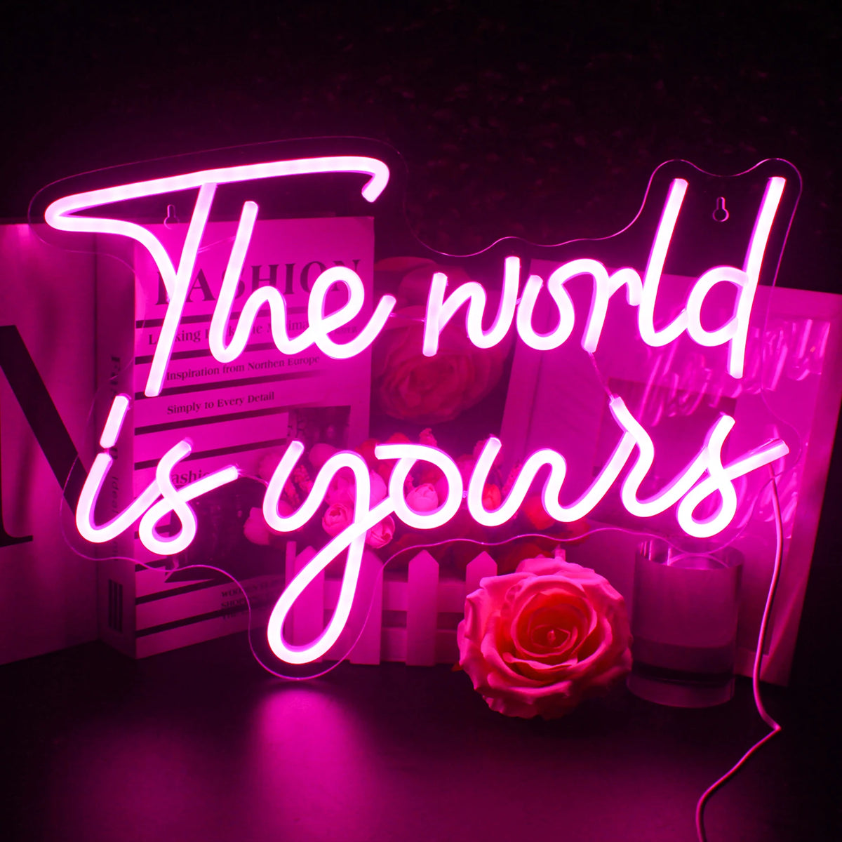 En levande LED-neonskylt som visar frasen "The World Is Yours" i ett kursivt teckensnitt.