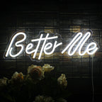 En elegant LED-neonskylt som visar orden "Better Me" i livfulla vita kursiva bokstäver.