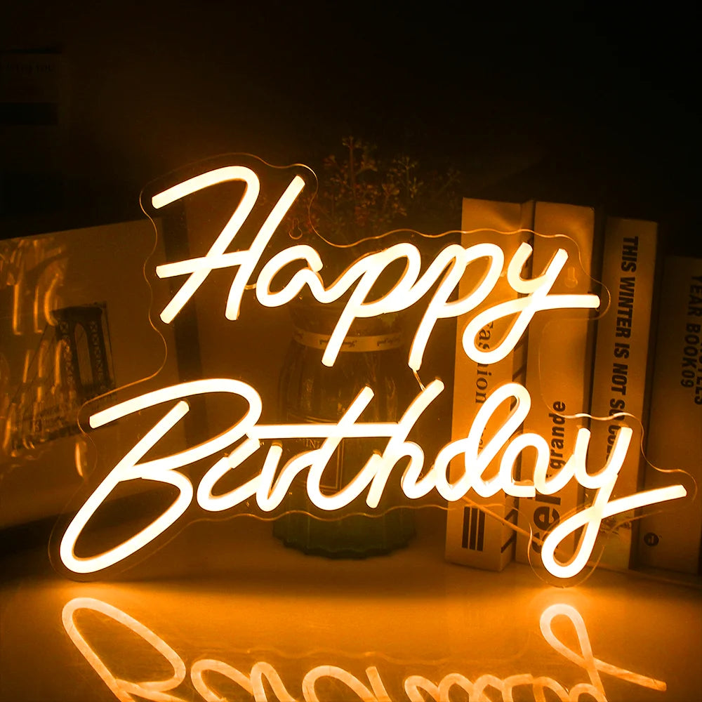 En livlig "Happy Birthday" LED neonskylt lyser mot en mörk bakgrund.