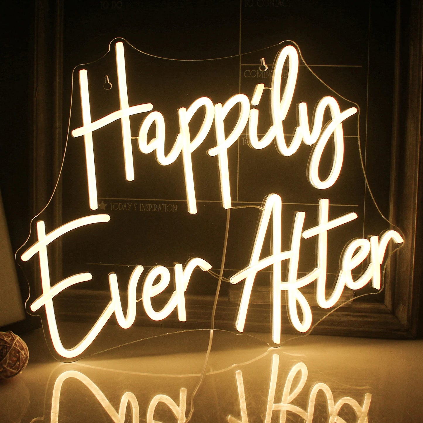 The image showcases a beautifully crafted LED neon sign that spells out "Happily Ever After" in a flowing, cursive script.