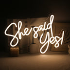 En levande, handgjord LED-neonskylt som visar frasen "She Said Yes.
