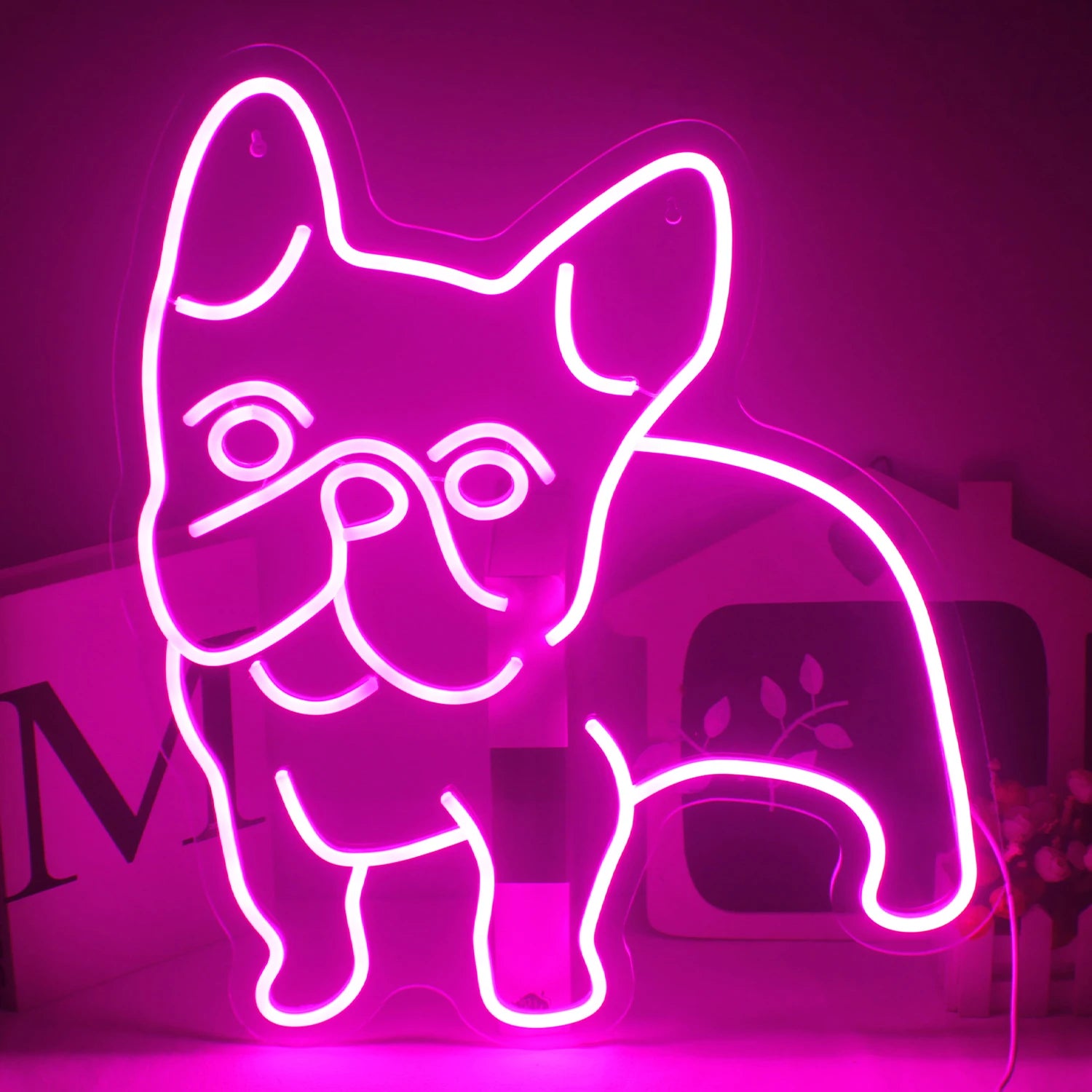 The image features a vibrant pink LED neon sign shaped in the outline of a dog.