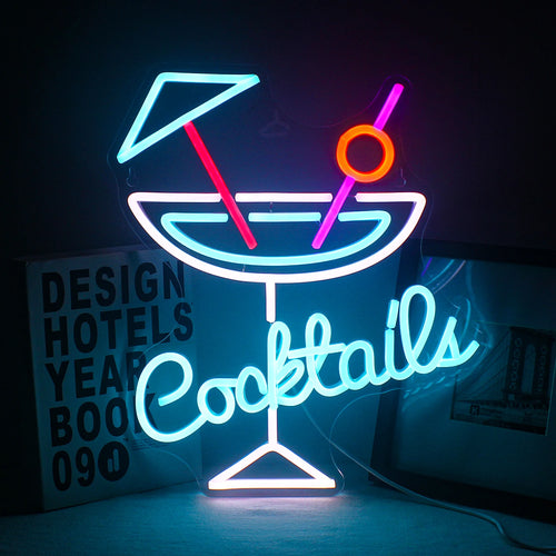 Bilden har en levande LED-neonskylt som visar ordet "Cocktails" i ett lekfullt, kursivt teckensnitt.