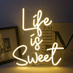 Bilden har en levande, handgjord LED-neonskylt i ljusa, glödande färger som förtydligar frasen "Life is Sweet.