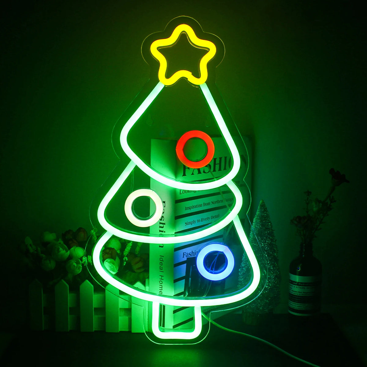 En festlig julgran LED neonskylt lyser starkt mot en mörk bakgrund.