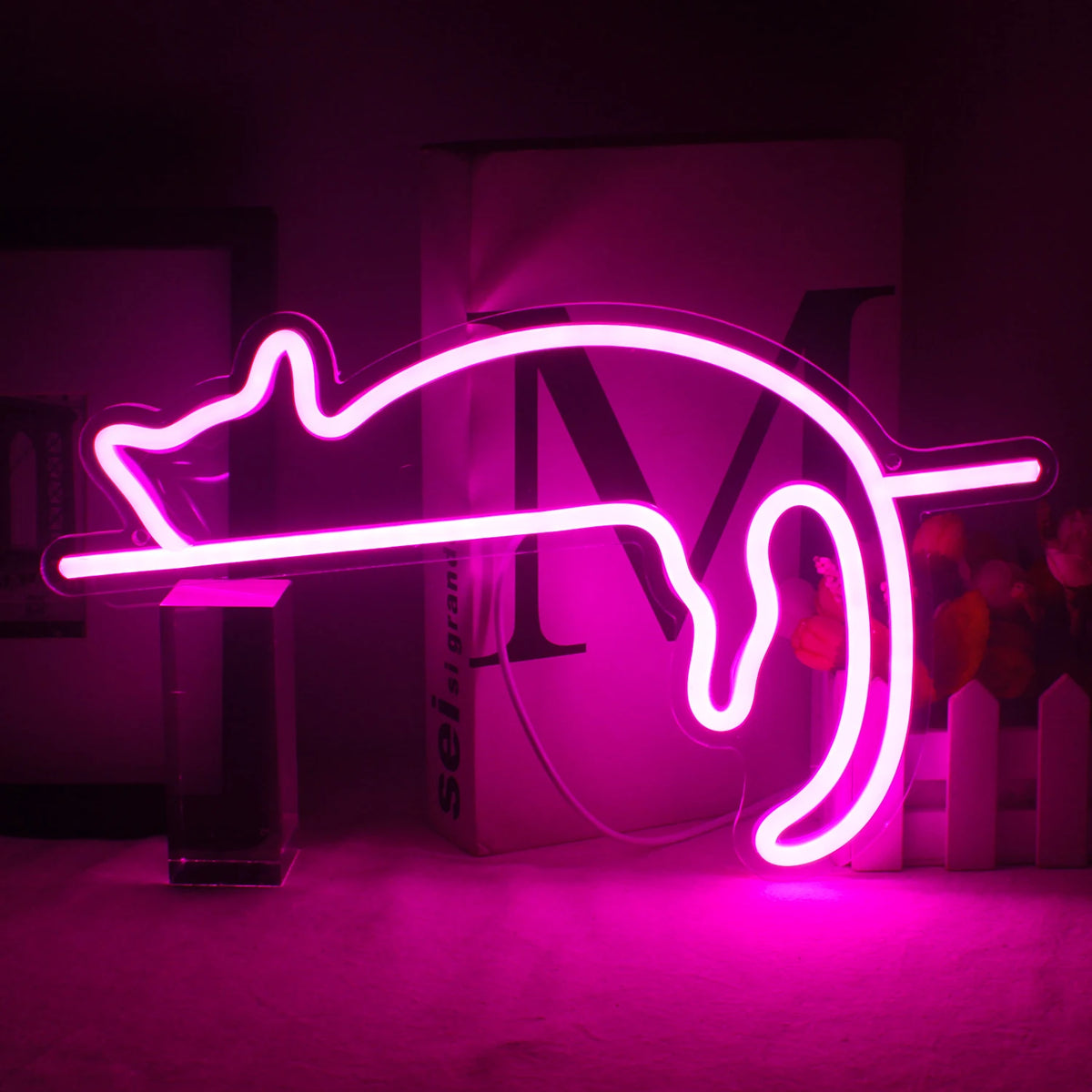 Bildbeskrivning: En levande LED-neonskylt formad som en katt är monterad på en vägg.