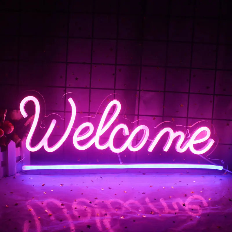 En livlig "Välkommen" LED neonskylt som visas mot en vanlig vit vägg.
