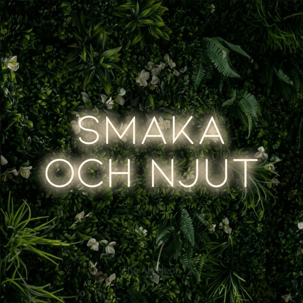 LED neon sign reading “smaka och njut”, arranged in 2 lines.