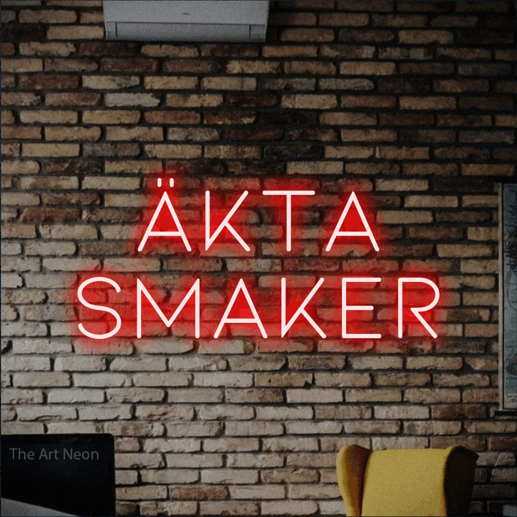 LED neon sign reading “Äkta Smaker”, arranged in 2 lines.