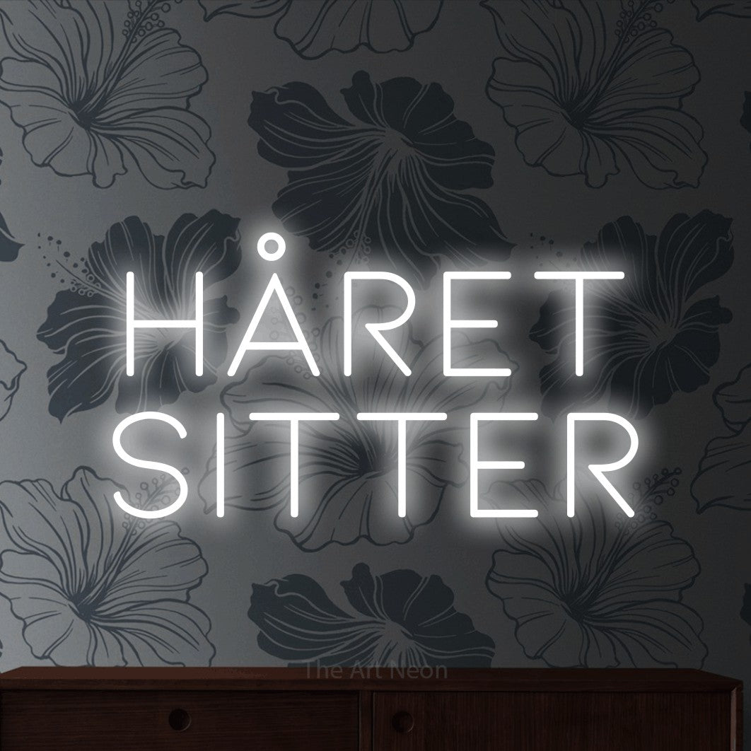 LED neon sign reading “Håret Sitter”, arranged in 2 lines.
