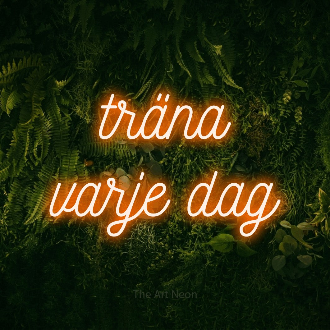 LED neon sign reading “träna varje dag”, arranged in 2 lines.