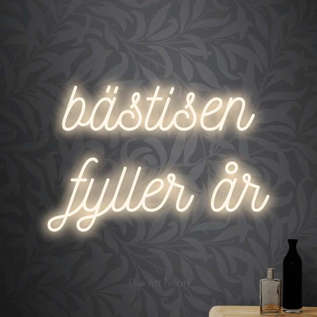 LED neon sign reading “bästisen fyller år”, arranged in 2 lines.