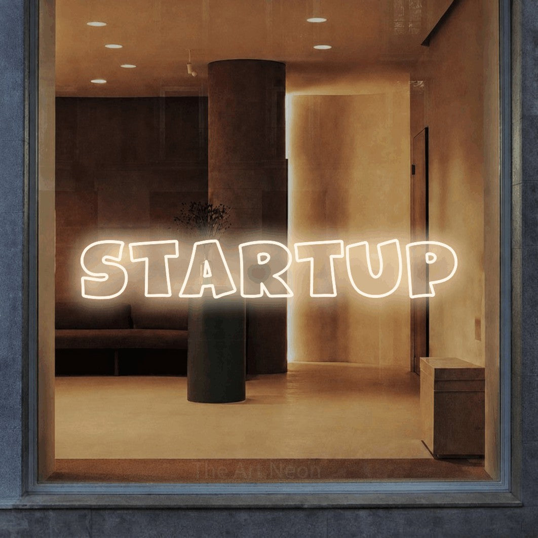 LED neon sign reading “STARTUP”, arranged in a single line.