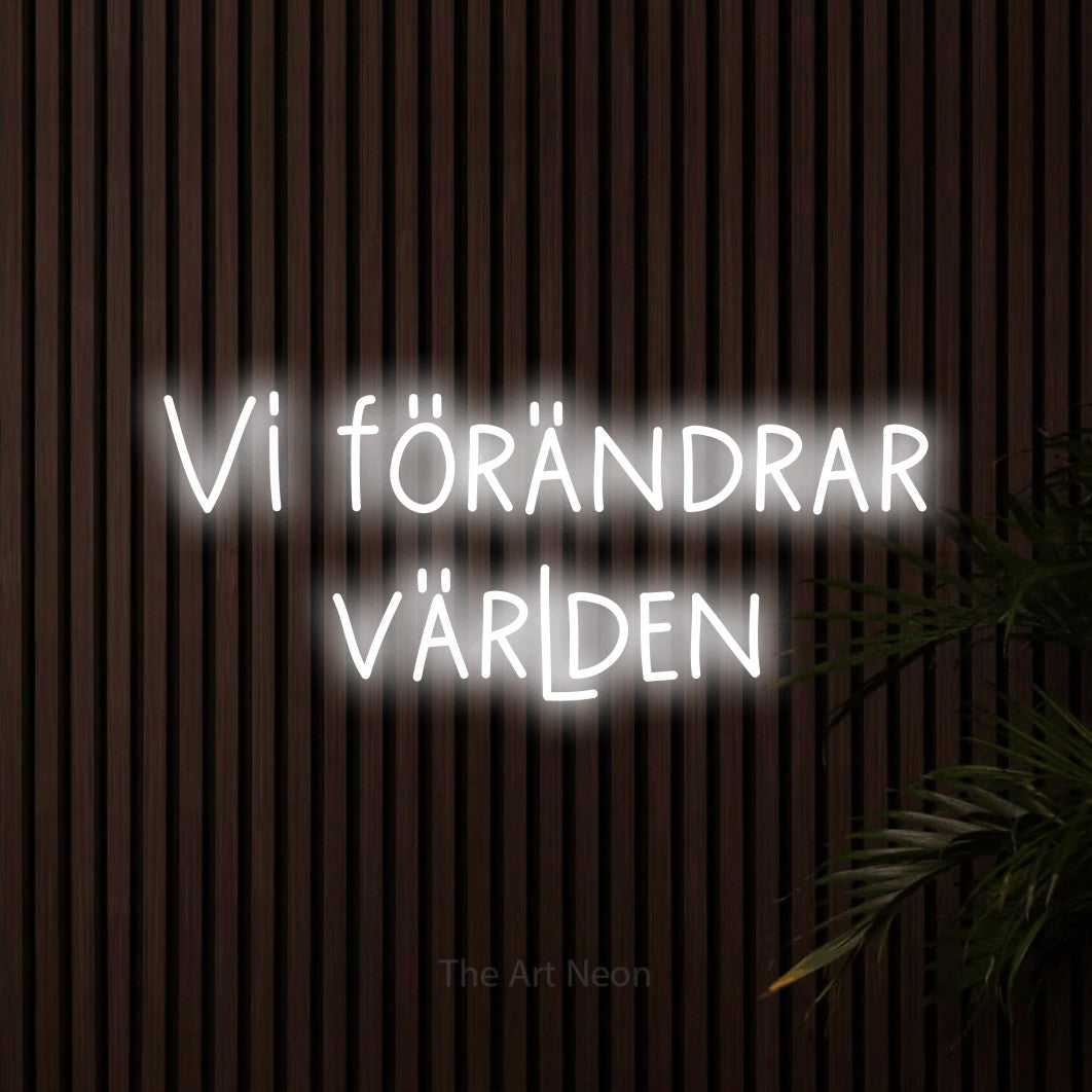 LED neon sign reading “Vi förändrar världen”, arranged in 2 lines.