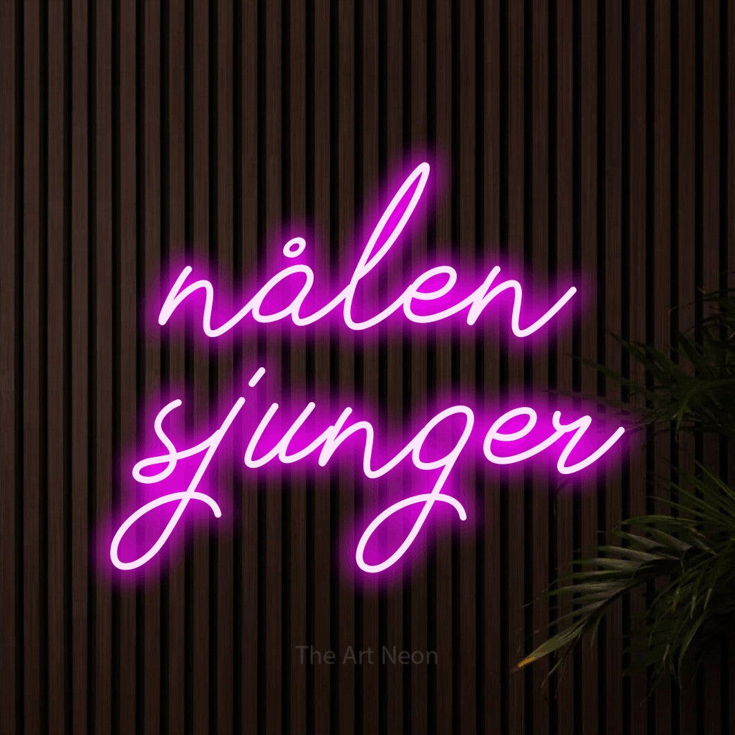LED neon sign reading “nålen sjunger”, arranged in 2 lines.