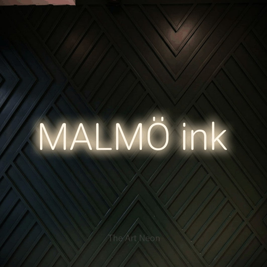 LED neon sign reading “MALMÖ ink”, arranged in a single line.