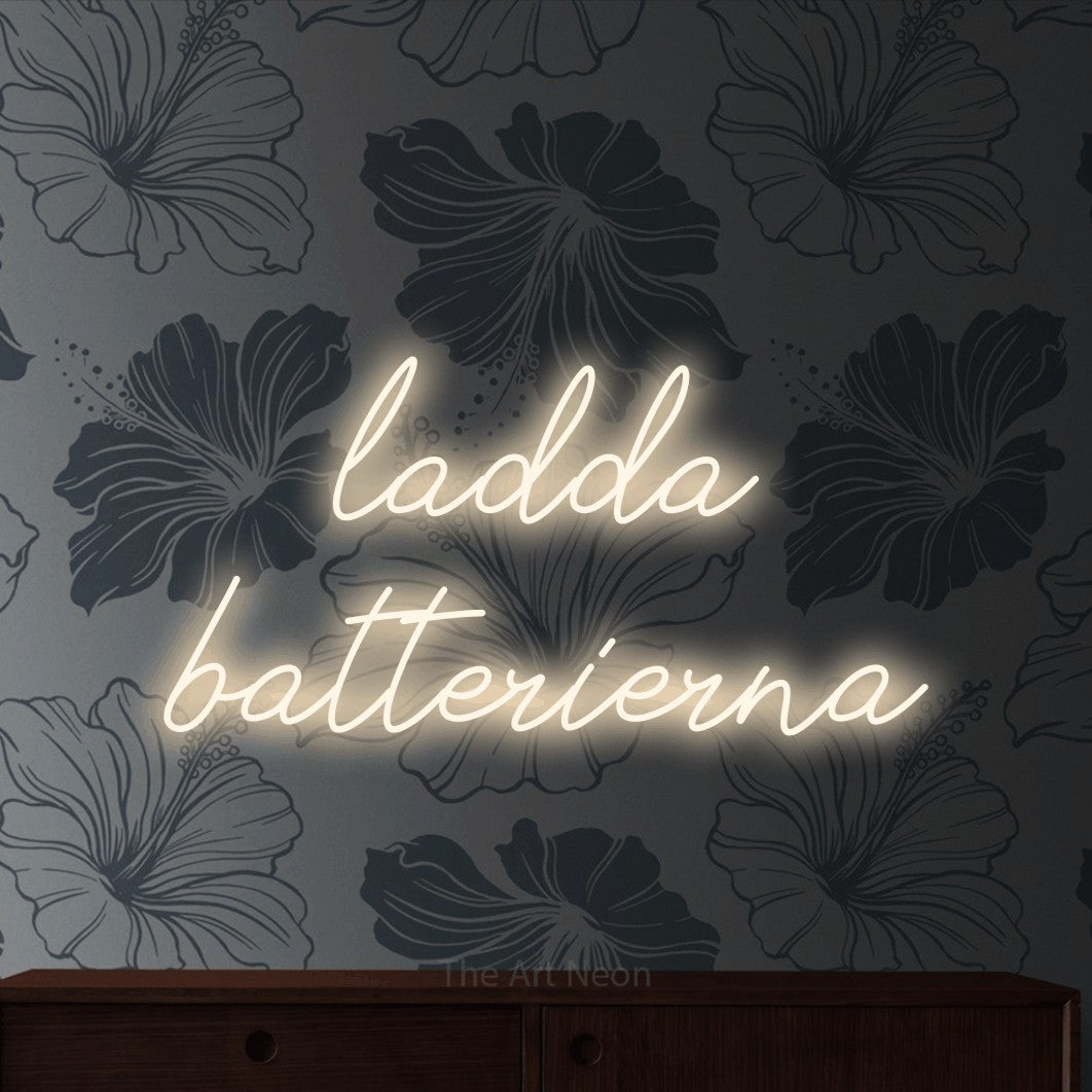LED neon sign reading “ladda batterierna”, arranged in 2 lines.