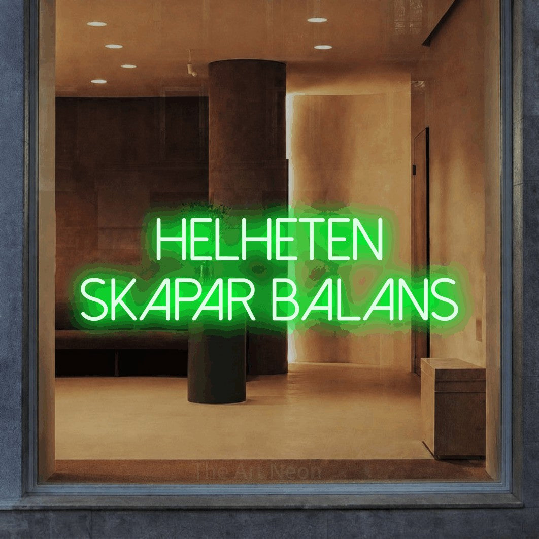 LED neon sign reading “HELHETEN skapar balans”, arranged in 2 lines.