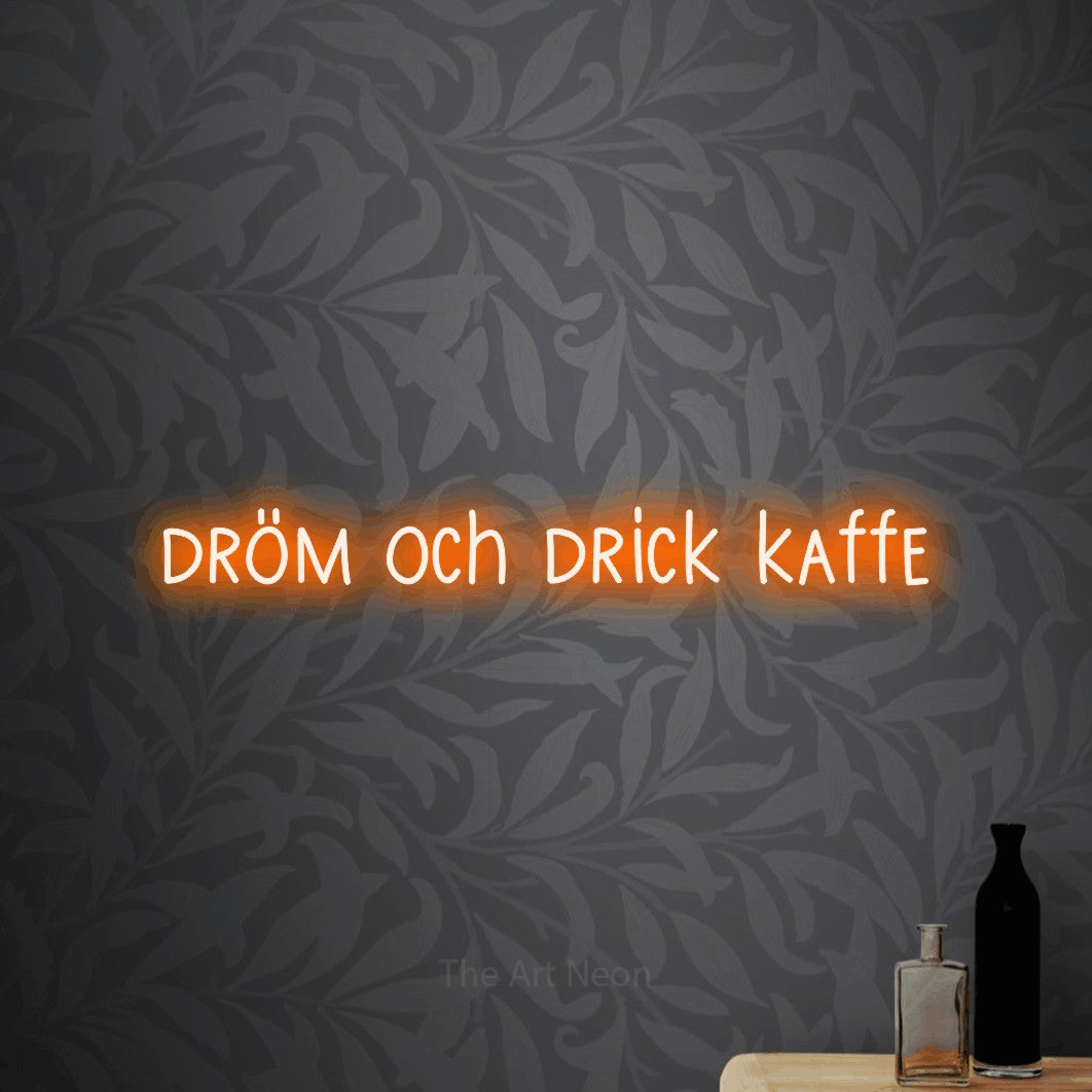 LED neon sign reading “dröm och drick kaffe”, arranged in a single line.