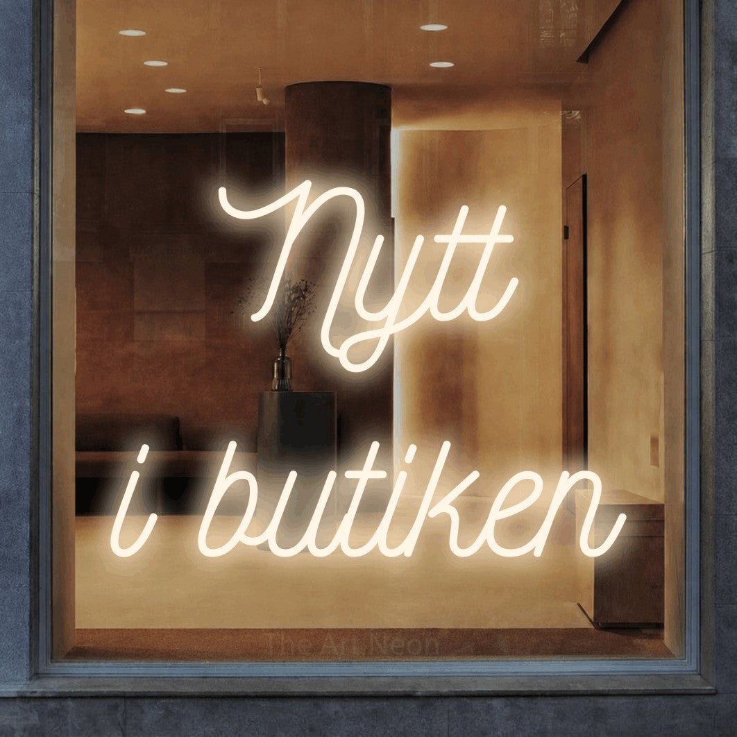 LED neon sign reading “Nytt i butiken”, arranged in 2 lines.