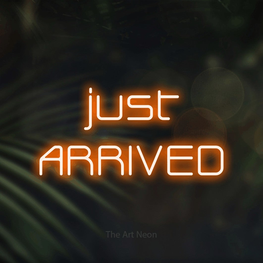 LED neon sign reading “just ARRIVED”, arranged in 2 lines.