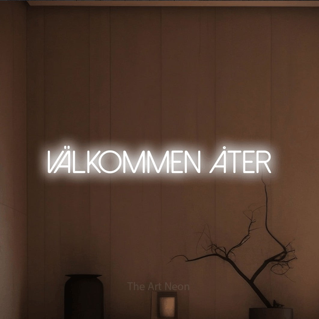 LED neon sign reading “välkommen åter”, arranged in a single line.